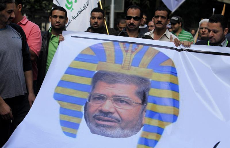 Egyptian protesters hold a banner depicting Morsi as a pharaoh, during a rally expressing opposition to Morsi's decrees, in Cairo, on Nov. 23. Egyptian protesters hold a banner depicting Morsi as a pharaoh, during a rally expressing opposition to Morsi's decrees, in Cairo, on Nov. 23.