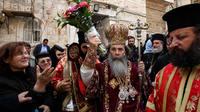 Patriarch Theophilos III, the Greek Orthodox patriarch of Jerusalem (center), splashes holy water toward worshippers after the washing of the feet ceremony in front of the Church of the Holy Sepulcher in Jerusalem in 2009, during Easter celebrations. A cr Patriarch Theophilos III, the Greek Orthodox patriarch of Jerusalem (center), splashes holy water toward worshippers after the washing of the feet ceremony in front of the Church of the Holy Sepulcher in Jerusalem in 2009, during Easter celebrations. A cr
