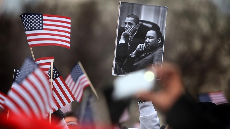 A spectator on the National Mall holds an image of President Obama and Martin Luther King during the 2013 presidential inauguration in January. A spectator on the National Mall holds an image of President Obama and Martin Luther King during the 2013 presidential inauguration in January.