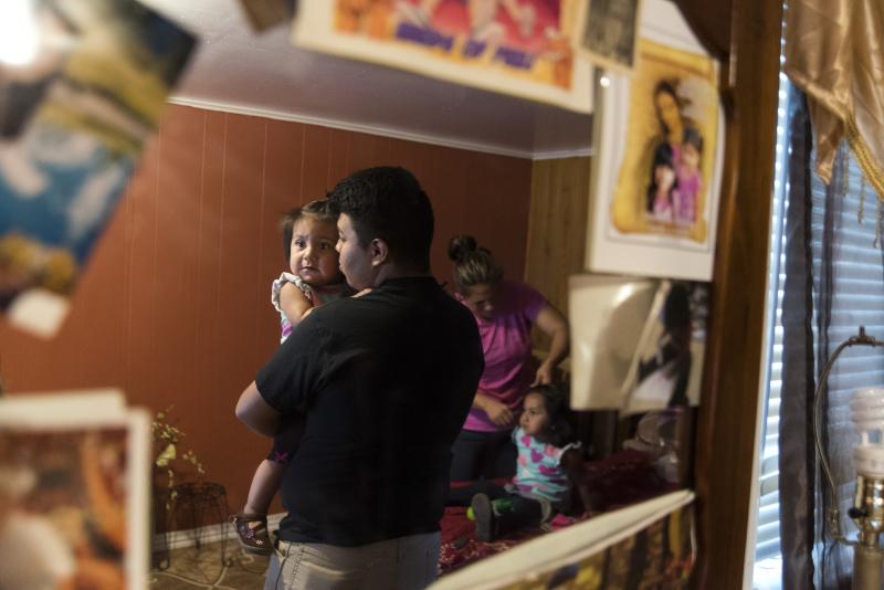 Jose Arriaga holds his youngest sister, Kaylin, while his mother, Veronica Arriaga, gets his middle sister, Krystal, ready for school. Jose just began his freshman year at Booker T. Washington High School in Tulsa, Okla. Jose Arriaga holds his youngest sister, Kaylin, while his mother, Veronica Arriaga, gets his middle sister, Krystal, ready for school. Jose just began his freshman year at Booker T. Washington High School in Tulsa, Okla.