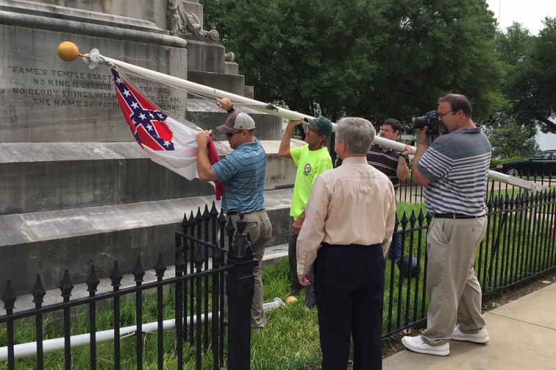 State workers take down a Confederate national flag on the grounds of the state Capitol on Wednesday in Montgomery, Ala. State workers take down a Confederate national flag on the grounds of the state Capitol on Wednesday in Montgomery, Ala.
