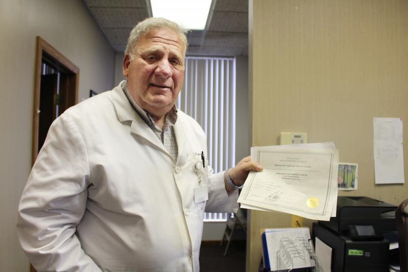 Dr. David Burkons holds the licensing certificates that allowed him to open a clinic that provides medical and surgical abortions. It took about 18 extra months of inspections, he says, to get the approval to offer surgical abortions. Dr. David Burkons holds the licensing certificates that allowed him to open a clinic that provides medical and surgical abortions. It took about 18 extra months of inspections, he says, to get the approval to offer surgical abortions.