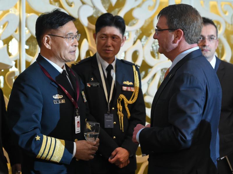 Sun Jianguo (left), from the Chinese People's Liberation Army Navy, chats with U.S. Secretary of Defense Ashton Carter in May during the ministerial luncheon at the 14th Asia Security Summit in Singapore. Each country has grown increasingly wary of the ot Sun Jianguo (left), from the Chinese People's Liberation Army Navy, chats with U.S. Secretary of Defense Ashton Carter in May during the ministerial luncheon at the 14th Asia Security Summit in Singapore. Each country has grown increasingly wary of the ot