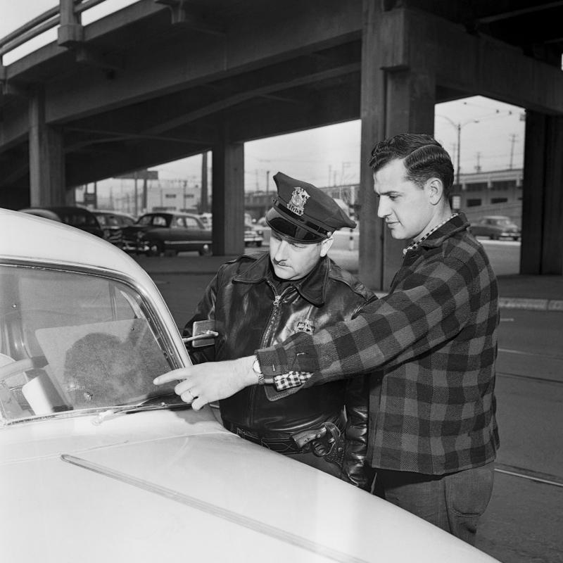A man shows his pitted windshield to a police officer in Seattle in 1954 A man shows his pitted windshield to a police officer in Seattle in 1954