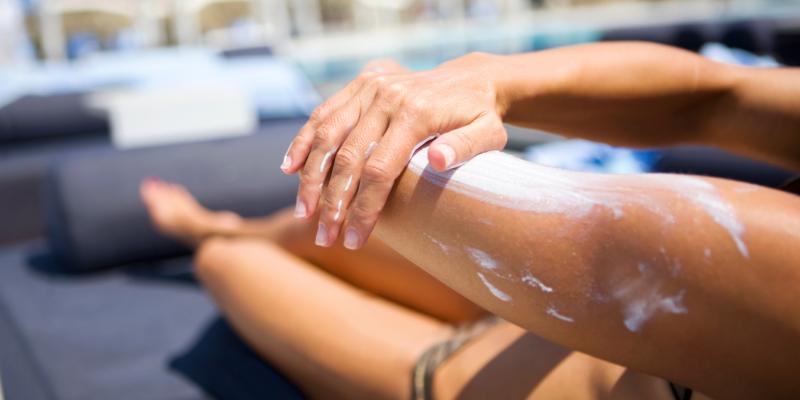 A woman applies sunscreen at the pool. A woman applies sunscreen at the pool.