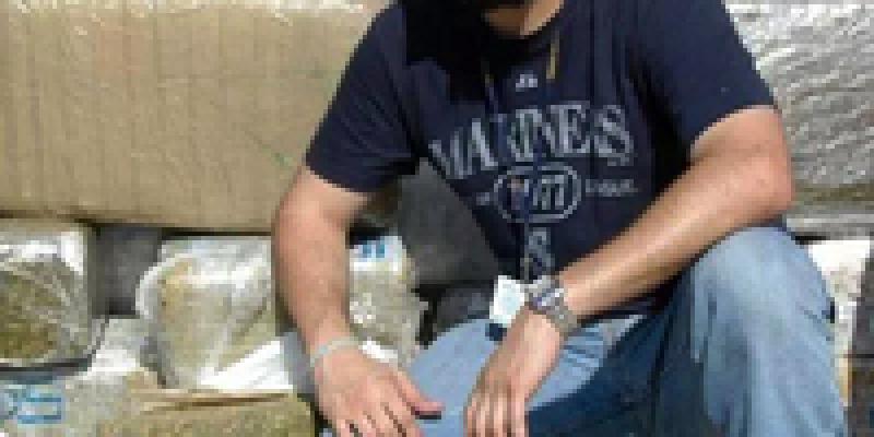 Jonathan Treviño poses in front of a drug bust. Jonathan Treviño poses in front of a drug bust.