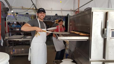 Pulling pizza out of the oven. Cooking at the Winston-Salem Greek Festival
