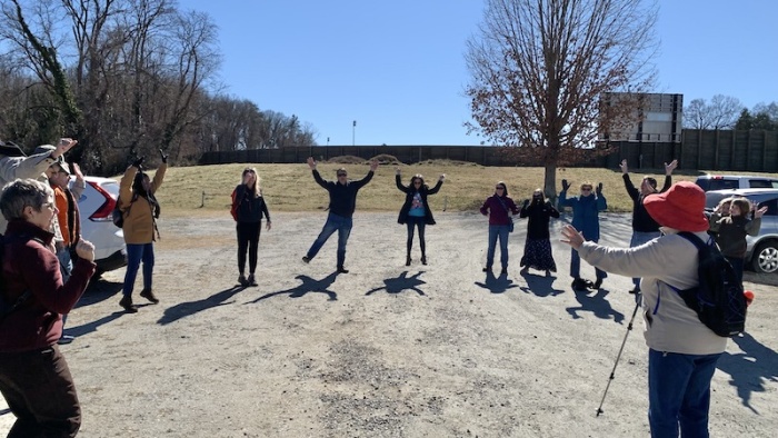 WFDD listeners warming up for their Listener Expedition with their hands in the air.