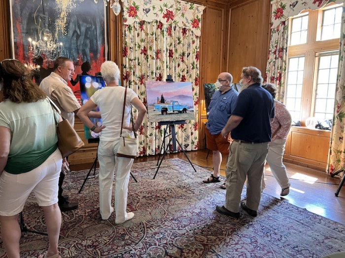 A crowd gathers around an easel with one of WFDD's photos of the year on display.