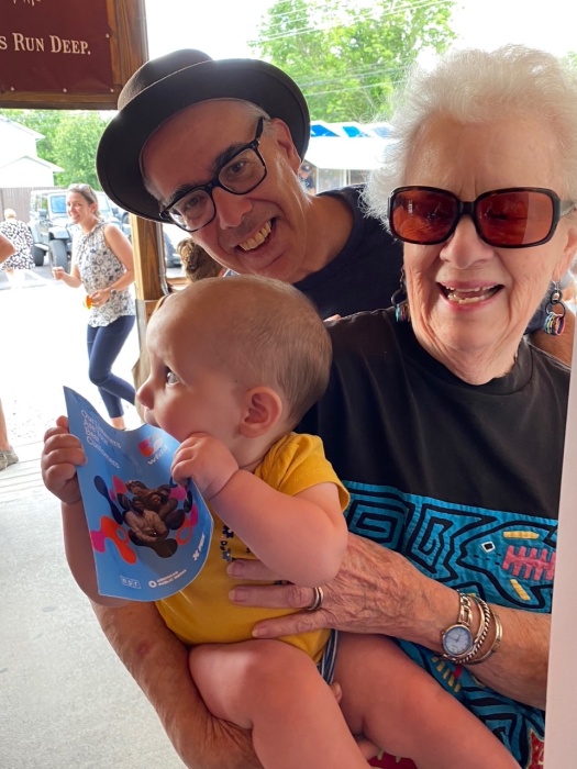 A WFDD employee poses for a picture with a baby during a Summer Bar Meetup event.