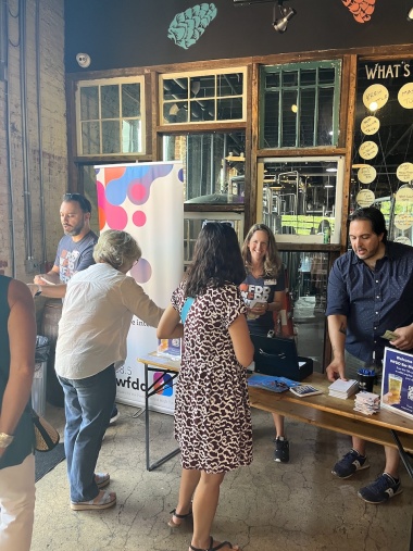 WFDD employees hand out information and take donations during a Summer Bar Meetup event.