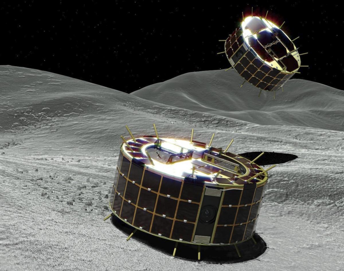 A computer graphic image provided by Japan's space agency shows two drum-shaped and solar-powered rovers on an asteroid. A Japanese unmanned spacecraft released two small rovers on the asteroid Ryugu last week