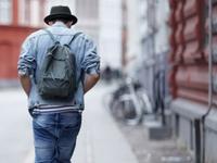 Rear view of a young guy walking down a city street. Rear view of a young guy walking down a city street.
