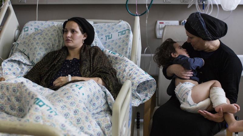 Odel Bennett, a 22-year-old Israeli woman, lies on a hospital bed as her mother Miriam Gal holds Odel's son Natan, 2, at the Hadassah Medical Center in Jerusalem. Bennett was stabbed in an Oct. 3 attack by a Palestinian that killed her husband and lightly Odel Bennett, a 22-year-old Israeli woman, lies on a hospital bed as her mother Miriam Gal holds Odel's son Natan, 2, at the Hadassah Medical Center in Jerusalem. Bennett was stabbed in an Oct. 3 attack by a Palestinian that killed her husband and lightly