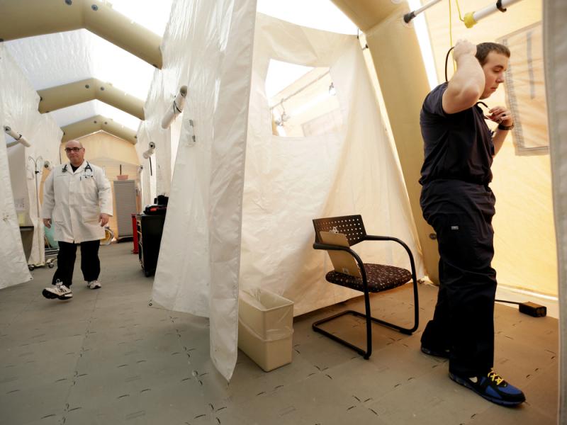 Physician assistants Scott Fillman (left) and Andrew Hunadi get ready to see patients with flu symptoms, in a tent erected just outside the emergency entrance at the Lehigh Valley Hospital in Allentown, Pa. Physician assistants Scott Fillman (left) and Andrew Hunadi get ready to see patients with flu symptoms, in a tent erected just outside the emergency entrance at the Lehigh Valley Hospital in Allentown, Pa.
