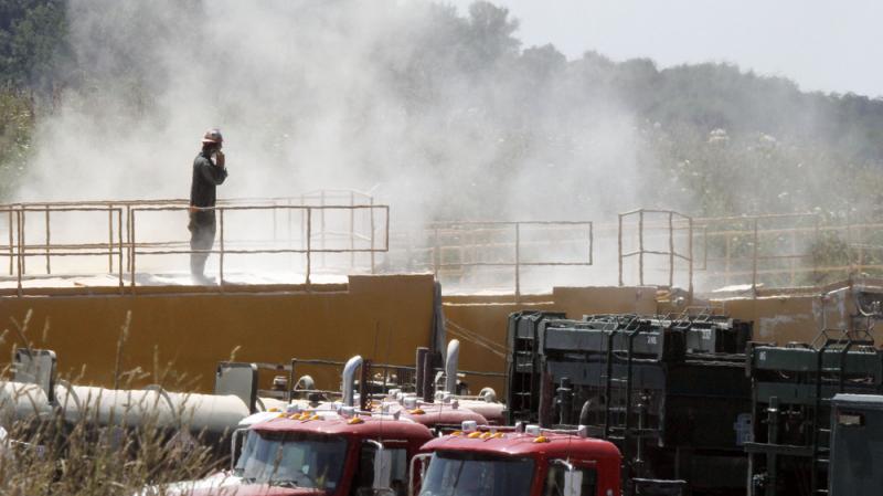 A worker stands on top of a storage bin on July 27, 2011, at a drilling operation in Claysville, Pa. The dust is from powder mixed with water for hydraulic fracturing. A worker stands on top of a storage bin on July 27, 2011, at a drilling operation in Claysville, Pa. The dust is from powder mixed with water for hydraulic fracturing.