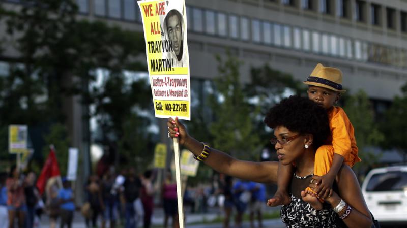 A woman, who refused to be identified, carries a young boy on her shoulders as she participates in a rally Sunday in Baltimore protesting the acquittal of George Zimmerman in the Florida shooting death of teenager Trayvon Martin. A woman, who refused to be identified, carries a young boy on her shoulders as she participates in a rally Sunday in Baltimore protesting the acquittal of George Zimmerman in the Florida shooting death of teenager Trayvon Martin.