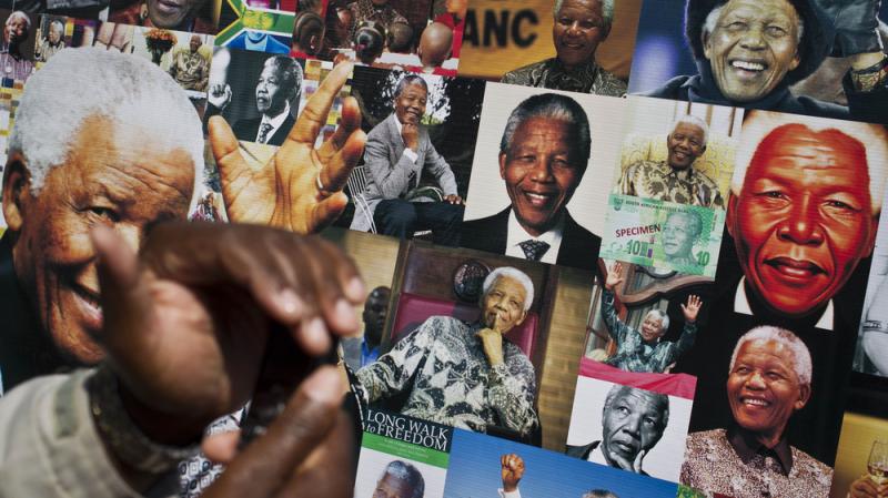 A well-wisher uses his phone to take a picture of a banner of photos of Nelson Mandela outside the Mediclinic Heart Hospital in Pretoria, where the former South African president is being treated. A well-wisher uses his phone to take a picture of a banner of photos of Nelson Mandela outside the Mediclinic Heart Hospital in Pretoria, where the former South African president is being treated.