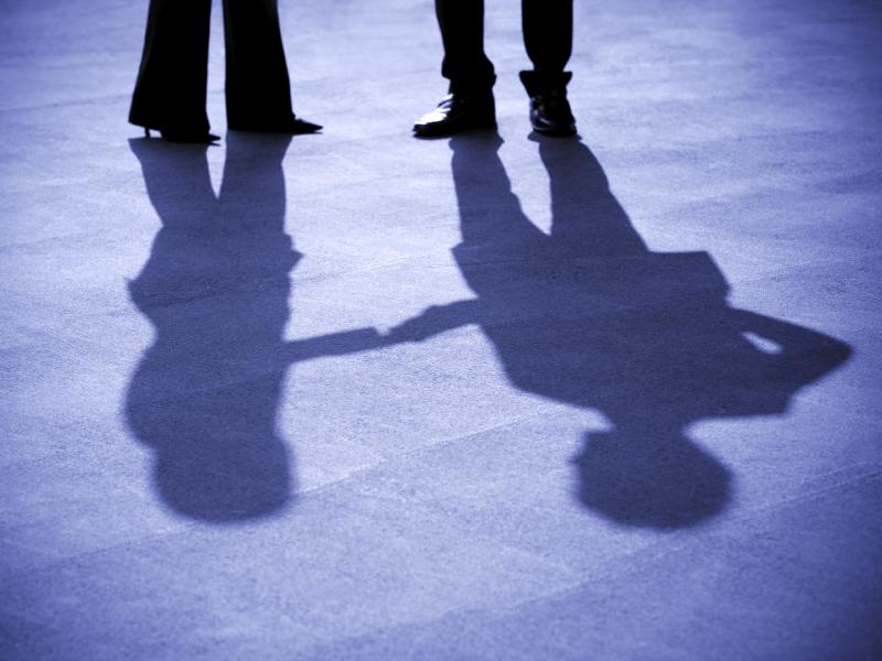 A businesswoman and businessman shake hands. A businesswoman and businessman shake hands.
