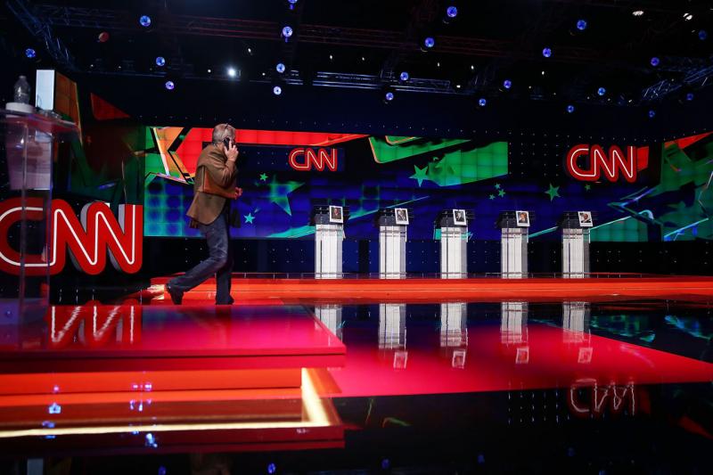A person walks on the stage set up for the Democratic presidential candidates, former U.S. Sen. Jim Webb (D-VA), U.S. Sen. Bernie Sanders (I-VT), Hillary Clinton, Former Maryland Gov. Martin O'Malley and former governor of Rhode Island Lincoln Chafee, a d