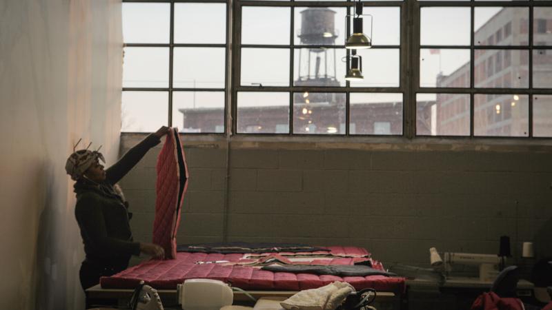 A worker with The Empowerment Plan creates a coat that will later be donated to a homeless person. The organization works inside Ponyride, a 30,000-square-foot warehouse near downtown Detroit. The warehouse hosts other local businesses, too. A worker with The Empowerment Plan creates a coat that will later be donated to a homeless person. The organization works inside Ponyride, a 30,000-square-foot warehouse near downtown Detroit. The warehouse hosts other local businesses, too.