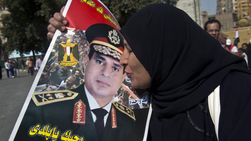 An Egyptian woman kisses a poster of Gen. Abdel-Fattah el-Sissi as she arrives at Cairo's Tahrir Square to mark the 40th anniversary of the 1973 Arab-Israeli war last month. Many are calling for the general to run for president next year, but so far he ha An Egyptian woman kisses a poster of Gen. Abdel-Fattah el-Sissi as she arrives at Cairo's Tahrir Square to mark the 40th anniversary of the 1973 Arab-Israeli war last month. Many are calling for the general to run for president next year, but so far he ha