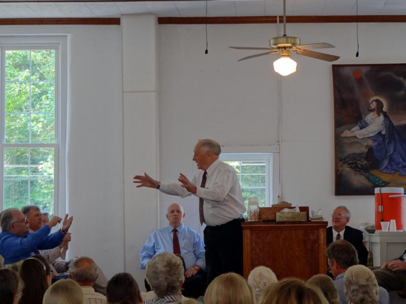 Church elder Elwood Cornett preaches at a recent reunion of Old Regular Baptists. Brother Don Pratt is seated behind him in a blue shirt and tie. Church elder Elwood Cornett preaches at a recent reunion of Old Regular Baptists. Brother Don Pratt is seated behind him in a blue shirt and tie.