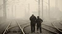 Men walk along a railway line in Beijing on Jan. 12, as air pollution reached hazardous levels. Men walk along a railway line in Beijing on Jan. 12, as air pollution reached hazardous levels.