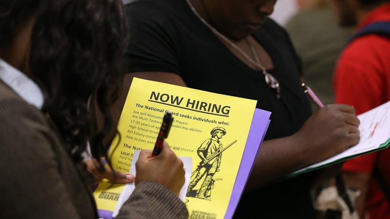 Attendees of a job fair in California in October fill out paperwork. Attendees of a job fair in California in October fill out paperwork.