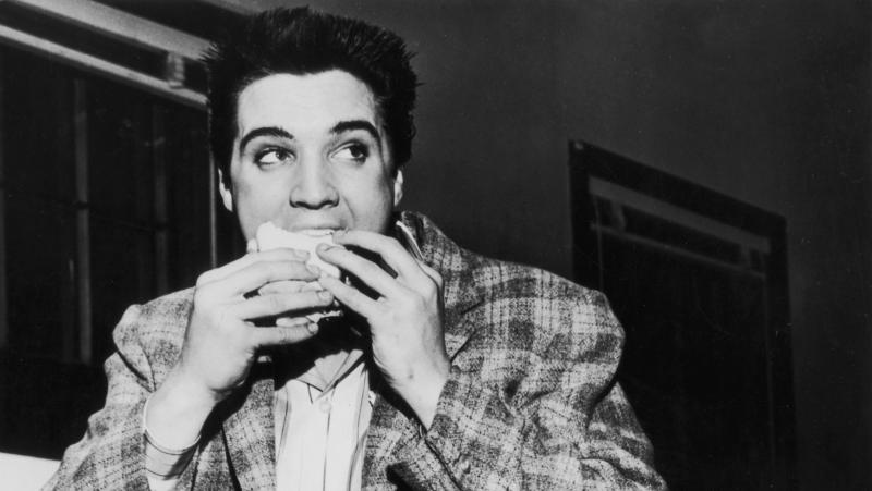 A still-trim Elvis Presley enjoys a sandwich in 1958. His love of fatty foods hadn't caught up to him yet. A still-trim Elvis Presley enjoys a sandwich in 1958. His love of fatty foods hadn't caught up to him yet.