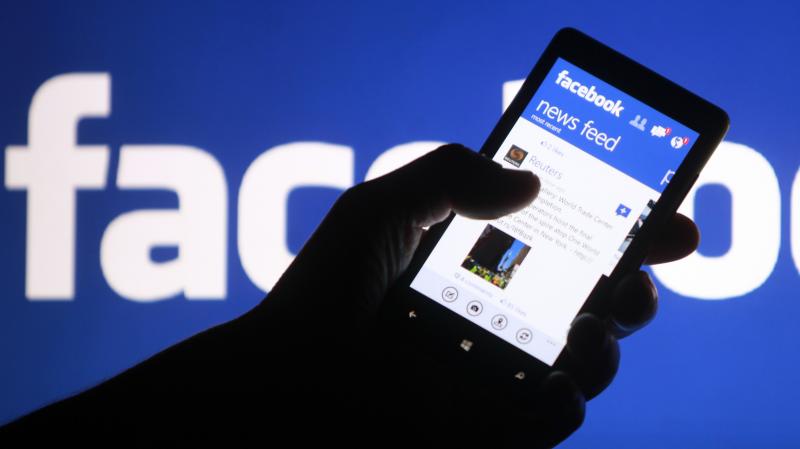 A smartphone user shows the Facebook application on his phone. A smartphone user shows the Facebook application on his phone.