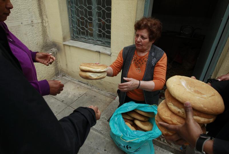 Georgia Kolia, 63, has two adult children, both unemployed. She works as a volunteer distributing loaves of bread at the Agia Zonis Orthodox church soup kitchen for the poor in Athens, Greece, in April 2012. Georgia Kolia, 63, has two adult children, both unemployed. She works as a volunteer distributing loaves of bread at the Agia Zonis Orthodox church soup kitchen for the poor in Athens, Greece, in April 2012.