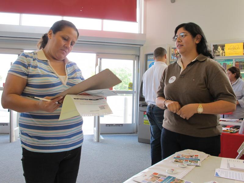 Enroll America outreach worker Rosy Mota (right) talks about the federal health care law with a CVS customer. Enroll America outreach worker Rosy Mota (right) talks about the federal health care law with a CVS customer.