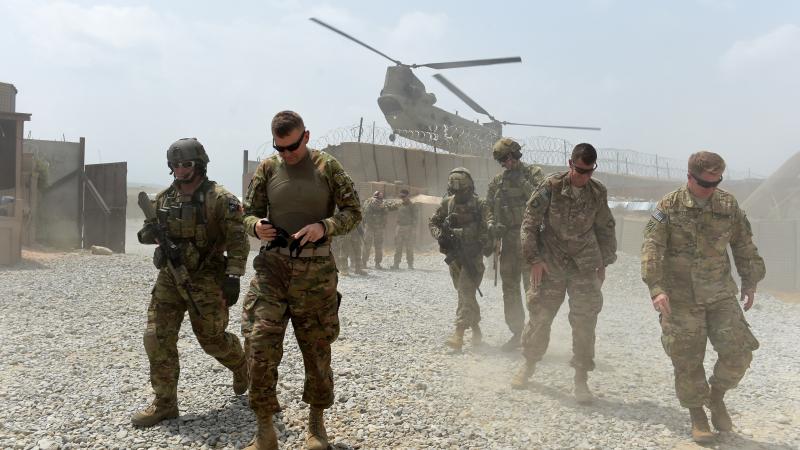 U.S. Army soldiers walk as a NATO helicopter flies overhead at coalition force Forward Operating Base (FOB) Connelly in the Khogyani district in the eastern province of Nangarhar on August 13, 2015. U.S. Army soldiers walk as a NATO helicopter flies overhead at coalition force Forward Operating Base (FOB) Connelly in the Khogyani district in the eastern province of Nangarhar on August 13, 2015.