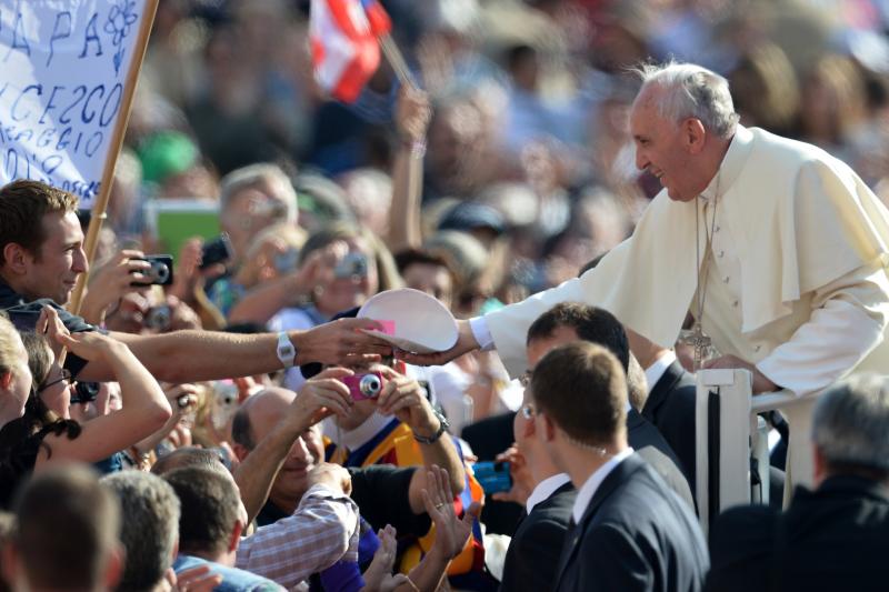 A young man gives a Catholic skullcap to Pope Francis as he greets the crowd before his general audience at St. Peter's Square at the Vatican on Oct. 16. A young man gives a Catholic skullcap to Pope Francis as he greets the crowd before his general audience at St. Peter's Square at the Vatican on Oct. 16.