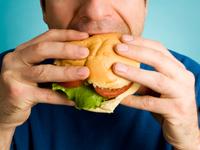 Man eats a hamburger Man eats a hamburger