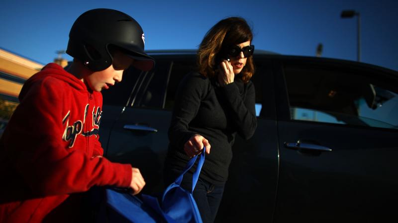 Yvonne Condes helps her son Alec get ready for baseball practice. Yvonne Condes helps her son Alec get ready for baseball practice.