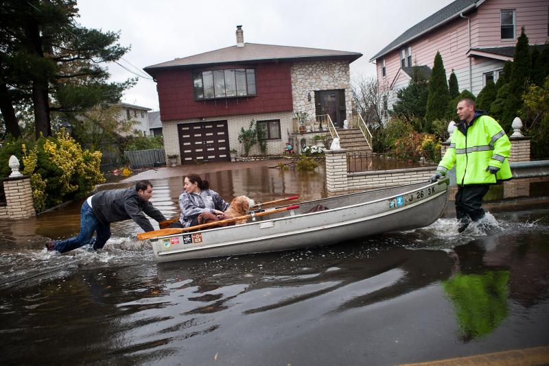 An emergency responder helps evacuate two people with a boat after their neighborhood in Little Ferry, N.J., was flooded. An emergency responder helps evacuate two people with a boat after their neighborhood in Little Ferry, N.J., was flooded.