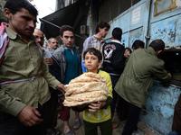 A Syrian boy carries a pile of bread as people crowd outside a bakery in the Salaheddin district of Aleppo, on Oct. 25, 2012. A Syrian boy carries a pile of bread as people crowd outside a bakery in the Salaheddin district of Aleppo, on Oct. 25, 2012.