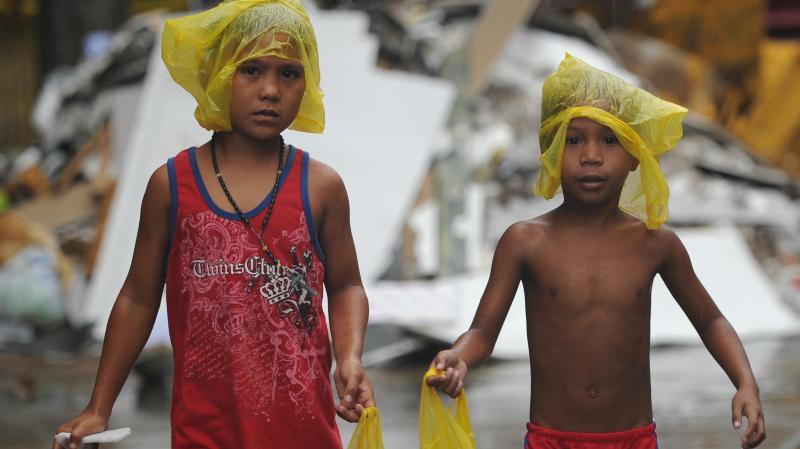 Young survivors of Typhoon Haiyan brave December rain as they ask for gifts from residents in the streets of Tacloban, the Philippines. Months after the storm, cleanup is still ongoing and many of the more than 6,000 dead have yet to be identified. Young survivors of Typhoon Haiyan brave December rain as they ask for gifts from residents in the streets of Tacloban, the Philippines. Months after the storm, cleanup is still ongoing and many of the more than 6,000 dead have yet to be identified.