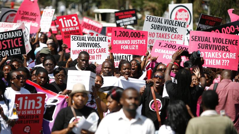 Hundreds take to the streets in Nairobi on Thursday, calling for justice for a 16-year-old girl dubbed "Liz," who was gang raped in rural Kenya. The men were caught by the police and let go after their punishment — cutting the grass at the police statio Hundreds take to the streets in Nairobi on Thursday, calling for justice for a 16-year-old girl dubbed "Liz," who was gang raped in rural Kenya. The men were caught by the police and let go after their punishment — cutting the grass at the police statio