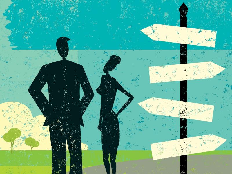 Two figures stand near a signpost. Two figures stand near a signpost.