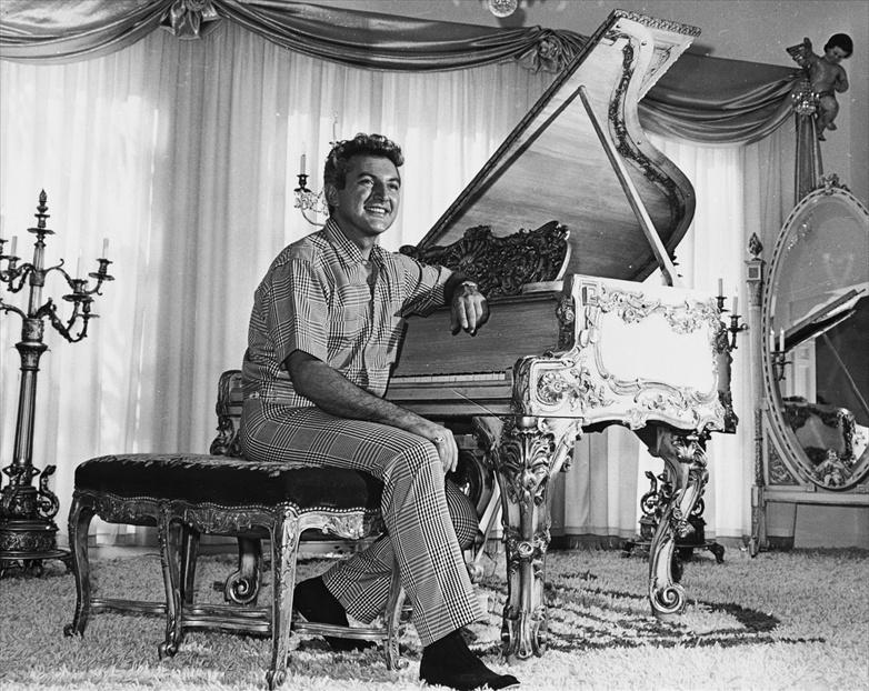Liberace sits at a gold-leafed piano in the living room of his then-new Hollywood mansion in November 1961. Liberace sits at a gold-leafed piano in the living room of his then-new Hollywood mansion in November 1961.