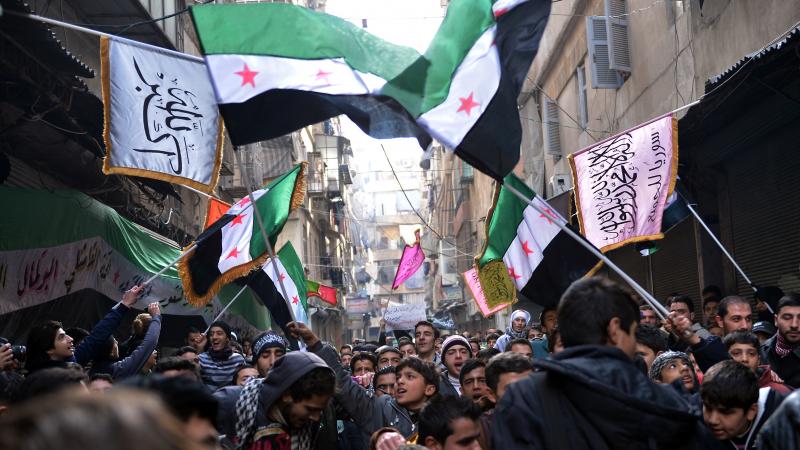 Secular demonstrators, shown at a protest march this month in Aleppo, wave the old Syrian flag (green, white, black and red) that has become the symbol of their opposition movement. Secular demonstrators, shown at a protest march this month in Aleppo, wave the old Syrian flag (green, white, black and red) that has become the symbol of their opposition movement.