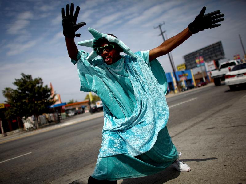 Robert Oliver, 27, dances on the corner of 28th and Crenshaw in west Los Angeles, dressed in a Statue of Liberty costume outside the offices of Liberty Income Tax. Robert Oliver, 27, dances on the corner of 28th and Crenshaw in west Los Angeles, dressed in a Statue of Liberty costume outside the offices of Liberty Income Tax.