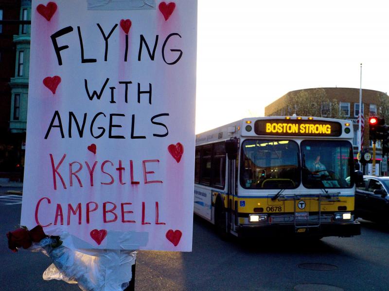 A sign reading "Flying With Angels Krystle Campbell," is seen Monday as a passing MBTA bus with "Boston Strong" displayed on its message board drives through Medford, Mass. A funeral service for Campbell, one of the three people killed in the marathon bom A sign reading "Flying With Angels Krystle Campbell," is seen Monday as a passing MBTA bus with "Boston Strong" displayed on its message board drives through Medford, Mass. A funeral service for Campbell, one of the three people killed in the marathon bom