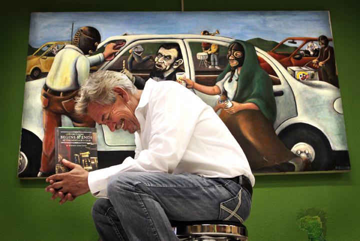 Author Benjamin Alire Saenz writes about life on the U.S.-Mexico border. Here he holds his latest book, Everything Begins and Ends at the Kentucky Club, in front of "$26," a painting by Francisco Delgado (the presidents in the painting appear on American Author Benjamin Alire Saenz writes about life on the U.S.-Mexico border. Here he holds his latest book, Everything Begins and Ends at the Kentucky Club, in front of "$26," a painting by Francisco Delgado (the presidents in the painting appear on American