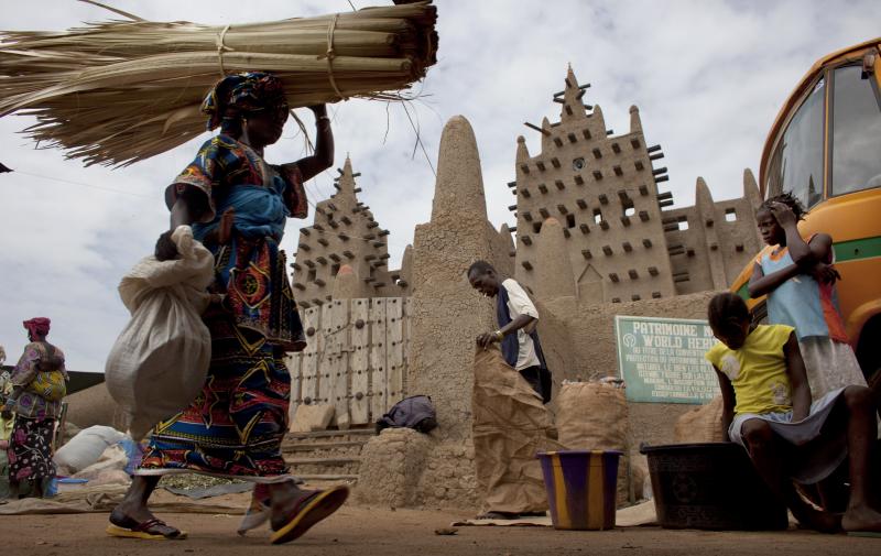 A woman walks by the Grand Mosque of Djenne on market day in Djenne, Mali, on Sept. 2. The UNESCO World Heritage-listed town is among the Malian tourist sites suffering from a huge drop in visitors after a coup took place in March and Islamist rebels seiz A woman walks by the Grand Mosque of Djenne on market day in Djenne, Mali, on Sept. 2. The UNESCO World Heritage-listed town is among the Malian tourist sites suffering from a huge drop in visitors after a coup took place in March and Islamist rebels seiz