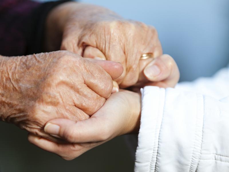 Elderly and young person holding hands Elderly and young person holding hands