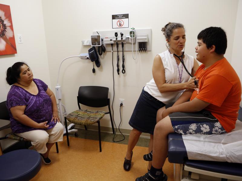 Families soon will be able to sign up for new health insurance options through the Affordable Care Act. In Washington, D.C., Dr. Cheryl Focht of Mary's Center performs a checkup of Jayson Gonzalez, 16, while his mother, Elizabeth Lopez, looks on. Families soon will be able to sign up for new health insurance options through the Affordable Care Act. In Washington, D.C., Dr. Cheryl Focht of Mary's Center performs a checkup of Jayson Gonzalez, 16, while his mother, Elizabeth Lopez, looks on.